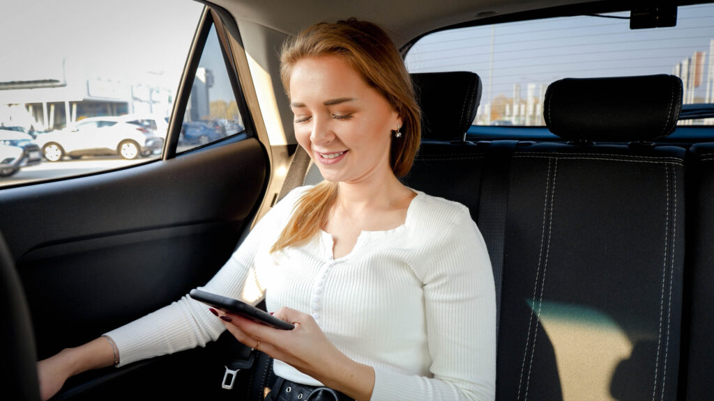 Businesswoman using mobile phone in taxi
